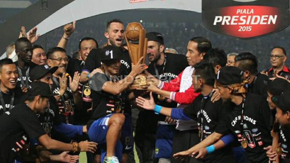 Atep bersiap-siap mengangkat trofi Piala Presiden.